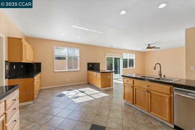 a kitchen with granite countertop a sink and a stove top oven