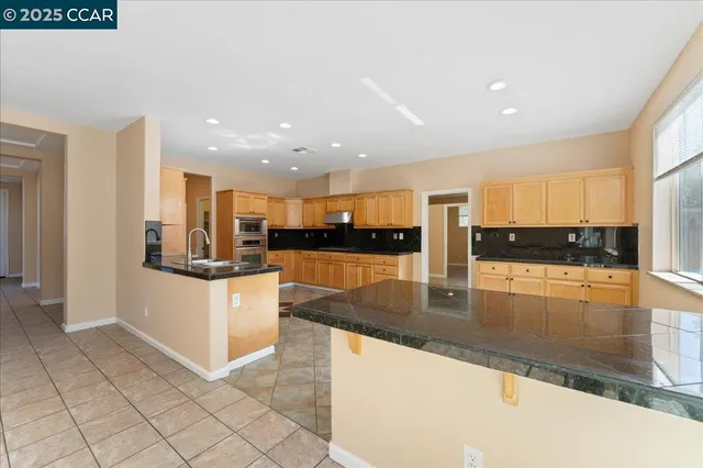a kitchen with stainless steel appliances granite countertop a refrigerator and a stove