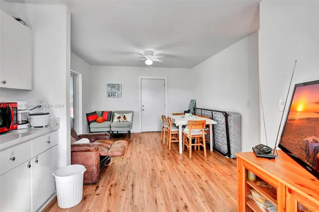 a work room with furniture a flat screen tv and a wooden floor