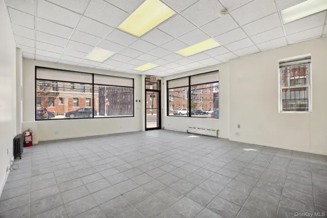 an empty room with windows and ceiling fan