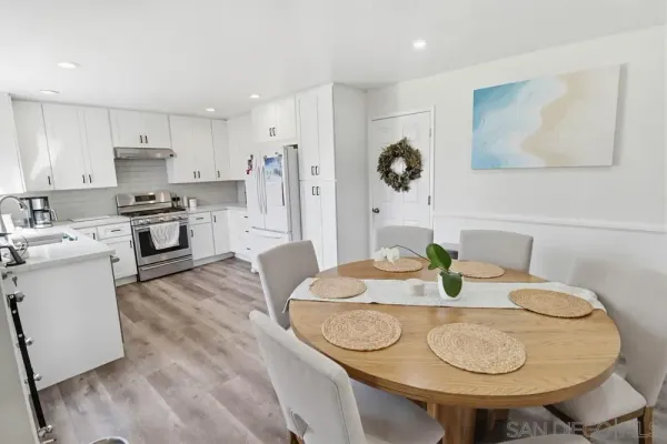 a kitchen with stainless steel appliances granite countertop a sink a microwave a stove and white cabinets