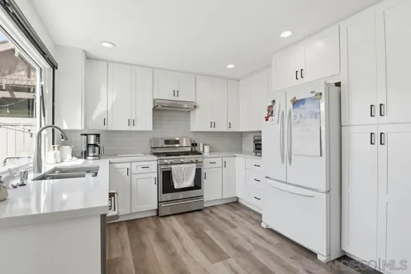 a kitchen with white cabinets and white appliances