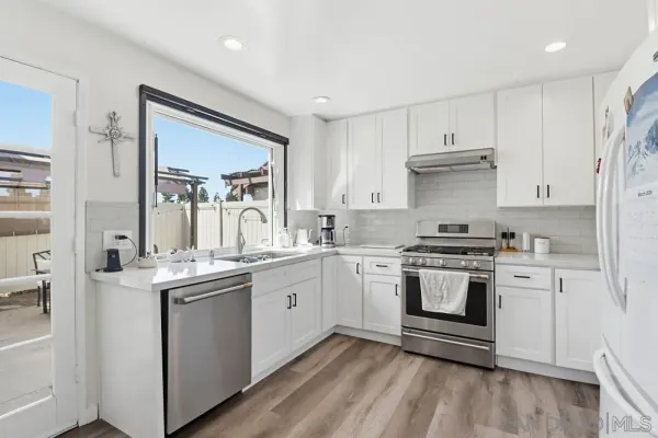 a kitchen with granite countertop a sink stove and cabinets