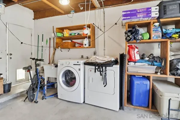 a utility room with dryer washer and a view of a living room