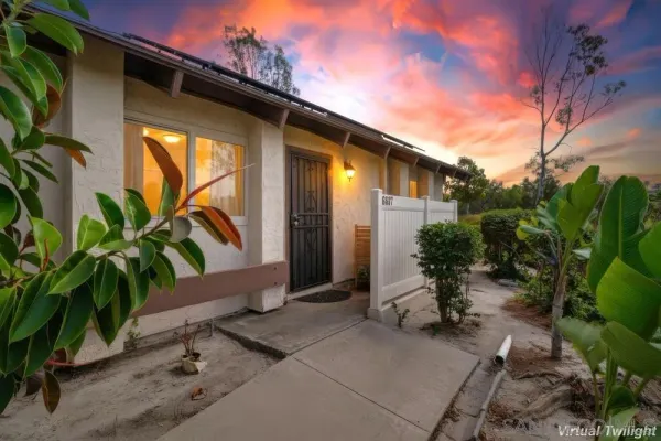 a backyard of a house with table and chairs with potted plants