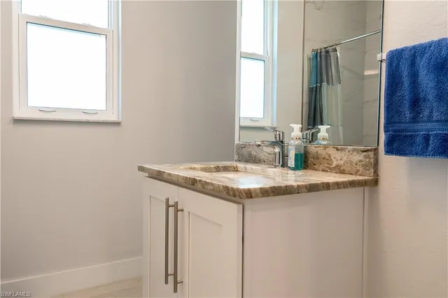 a bathroom with a granite countertop sink and a mirror