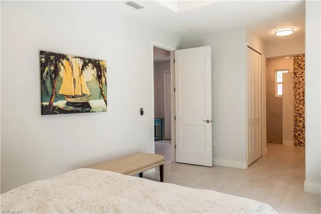 a bedroom with a bed and a painting on the wall