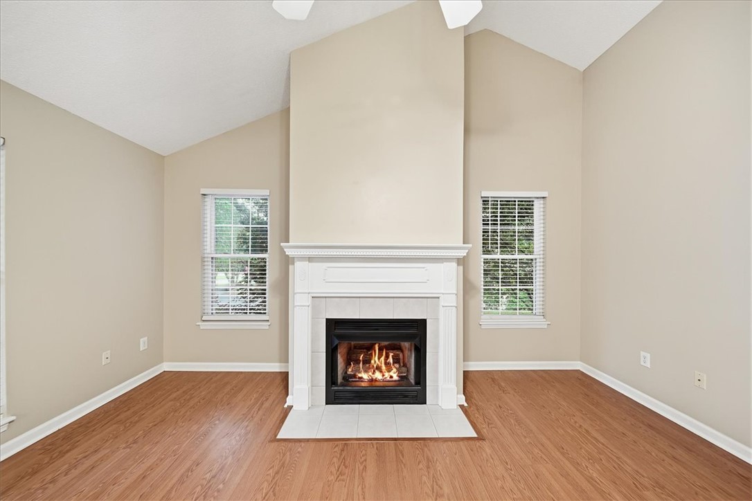 101 Grand Oak Circle Pendleton, SC 29670 - Photo 7 of 40 A striking fireplace with mantel and hearth grounds this inviting room featuring vaulted ceilings and rich wood flooring.