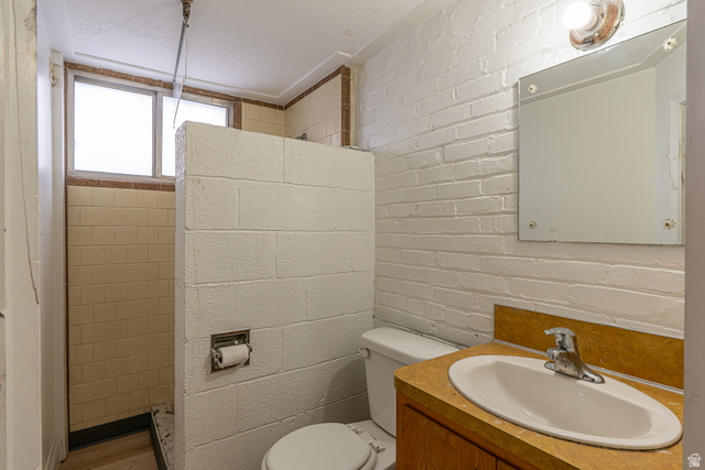 33 North 200 East Logan, UT 84321 - Photo 39 of 54 Full bath featuring vanity, tiled shower, and brick wall