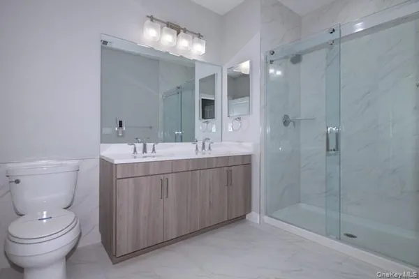 a bathroom with a double vanity sink mirror and toilet