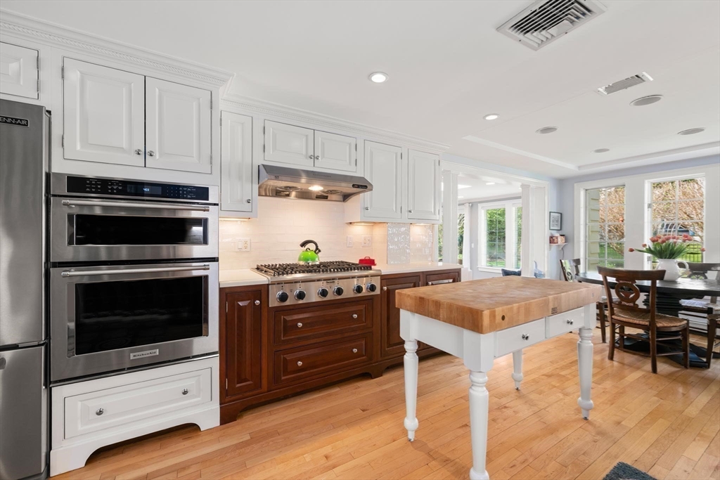 286 Quinobequin Road Newton, MA 02468 - Photo 8 of 31 a kitchen with a stove a window and wooden cabinets