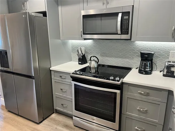 a kitchen with stainless steel appliances wooden cabinets and a stove top oven