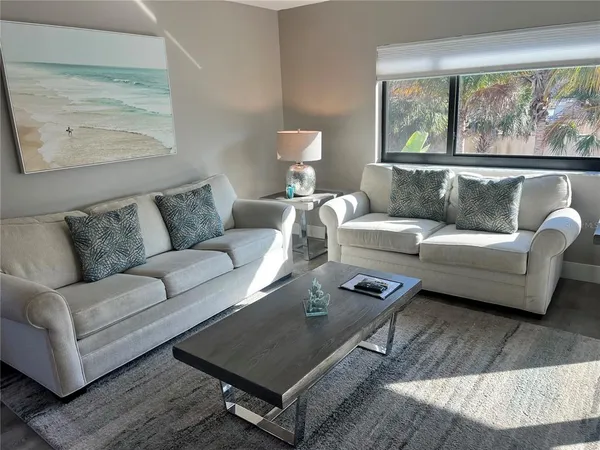a living room with furniture a rug and a large window