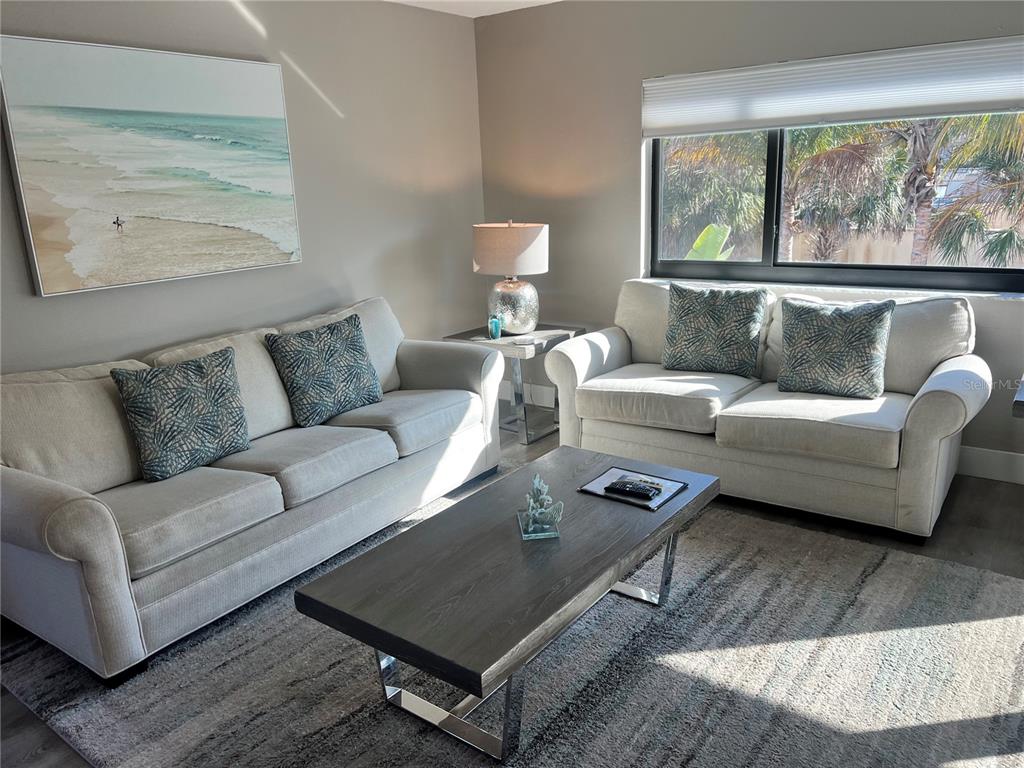1001 Point Of Rocks Road, Unit 208 Sarasota, FL 34242 - Photo 6 of 33 a living room with furniture a rug and a large window