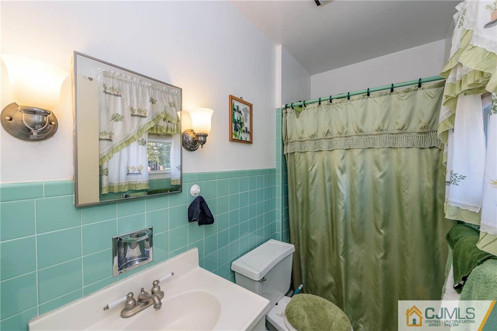 14 Gifford Road Somerset, NJ 08873 - Photo 21 of 25 a bathroom with a sink mirror and toilet