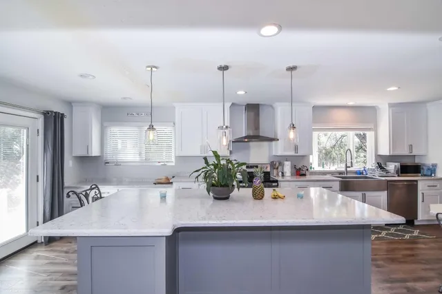 a kitchen with kitchen island a sink a counter space appliances and cabinets