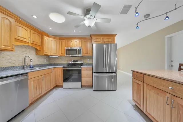 a kitchen with a refrigerator sink and cabinets