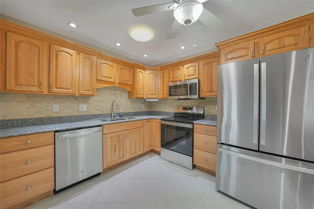 a kitchen with stainless steel appliances granite countertop a refrigerator sink and stove