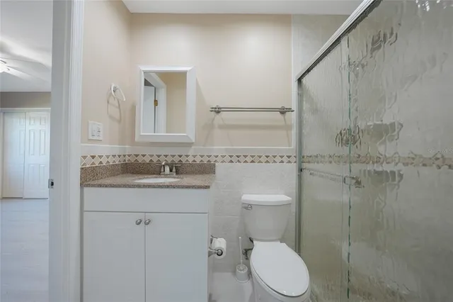a bathroom with a granite countertop toilet sink and mirror