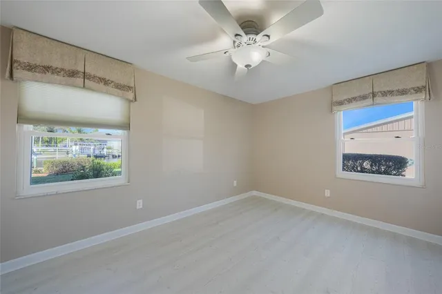 an empty room with a window and a ceiling fan
