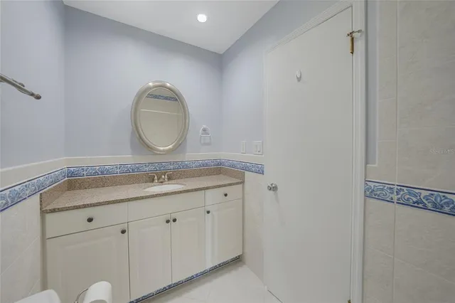 a bathroom with a granite countertop double vanity sink and mirror
