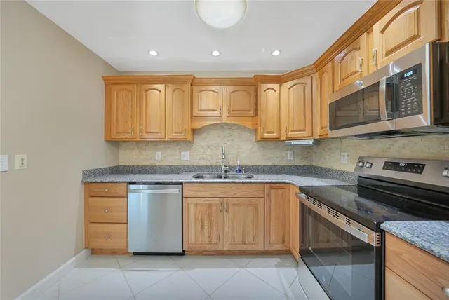 a kitchen with stainless steel appliances granite countertop a sink and a stove