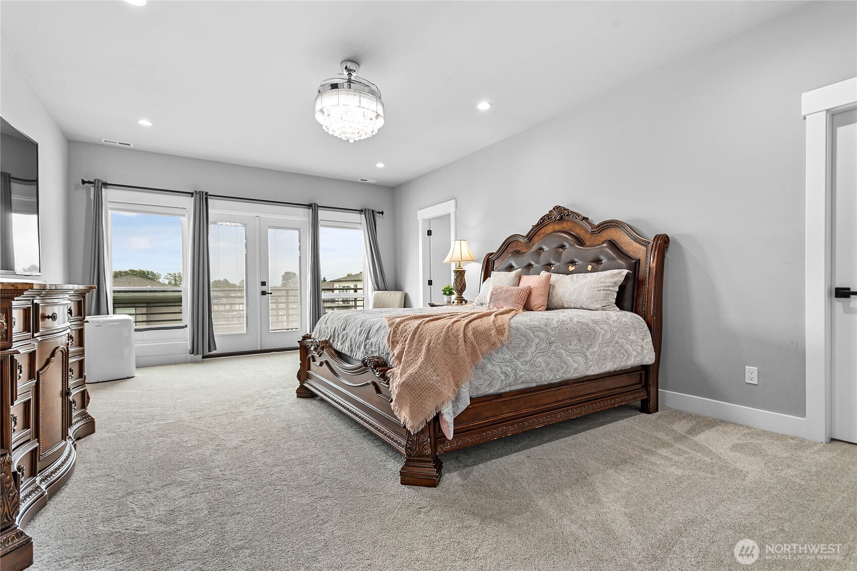 2144 Riverstone Loop Ferndale, WA 98248 - Photo 22 of 36 a spacious bedroom with a bed and a chandelier