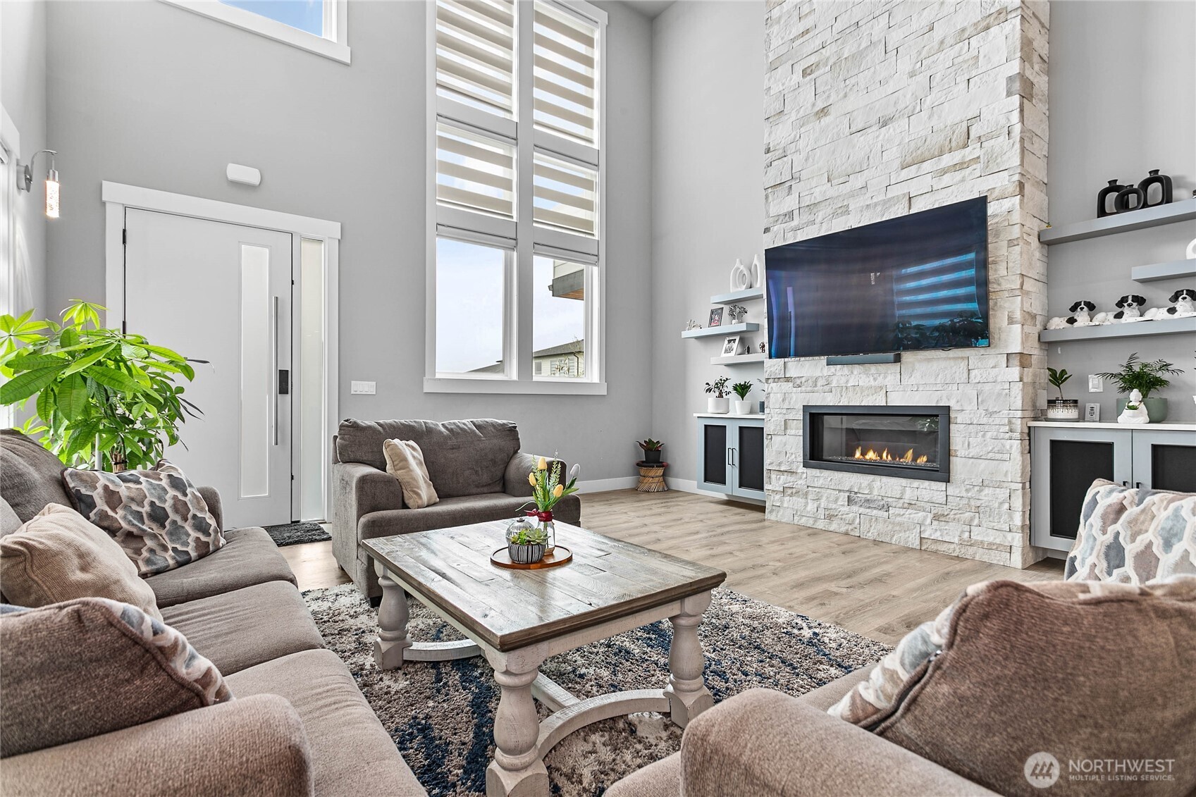 2144 Riverstone Loop Ferndale, WA 98248 - Photo 6 of 36 a living room with furniture a flat screen tv and a fireplace