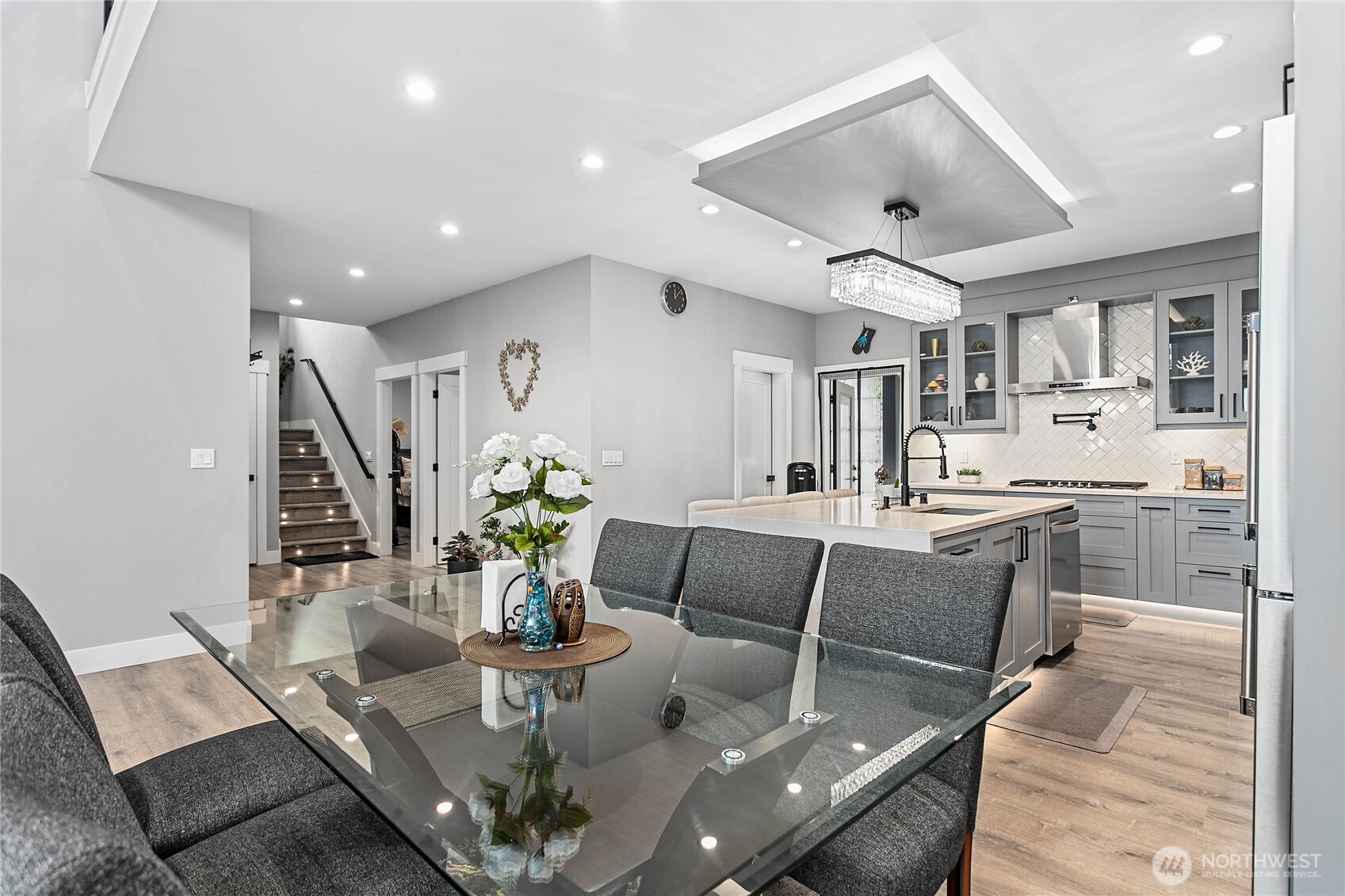 2144 Riverstone Loop Ferndale, WA 98248 - Photo 10 of 36 a living room with kitchen island furniture and a chandelier