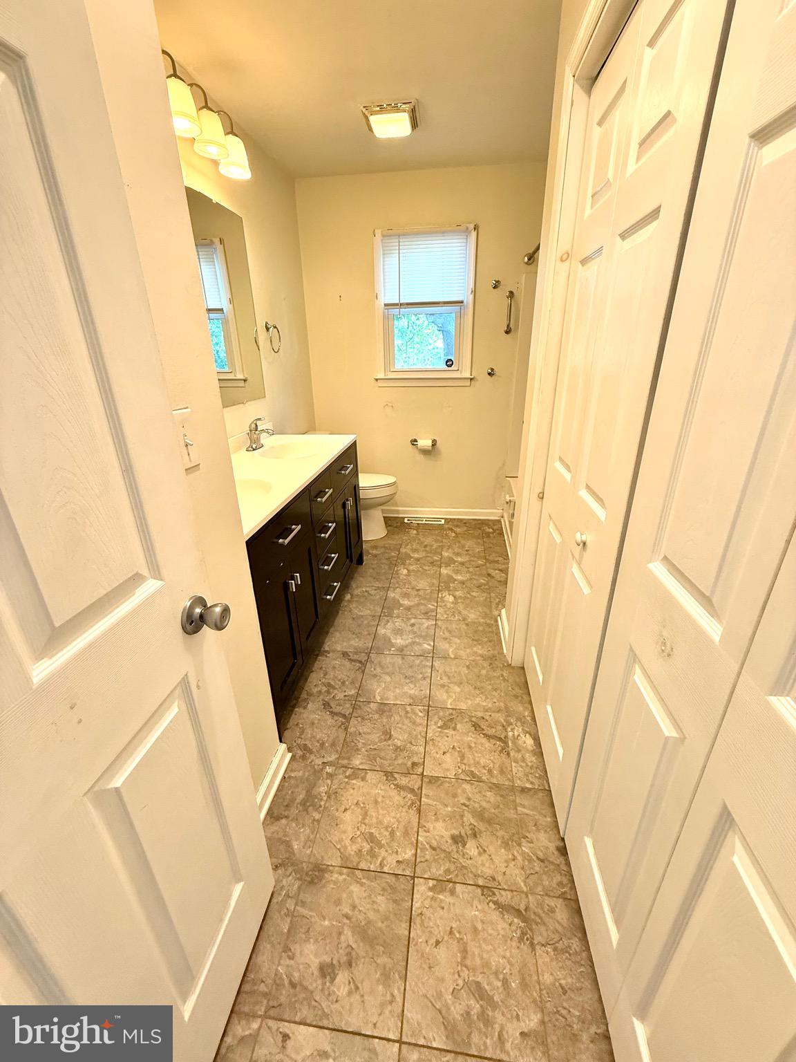 195 Mitscher Road Dover, DE 19901 - Photo 12 of 24 a bathroom with a sink a toilet a mirror and vanity