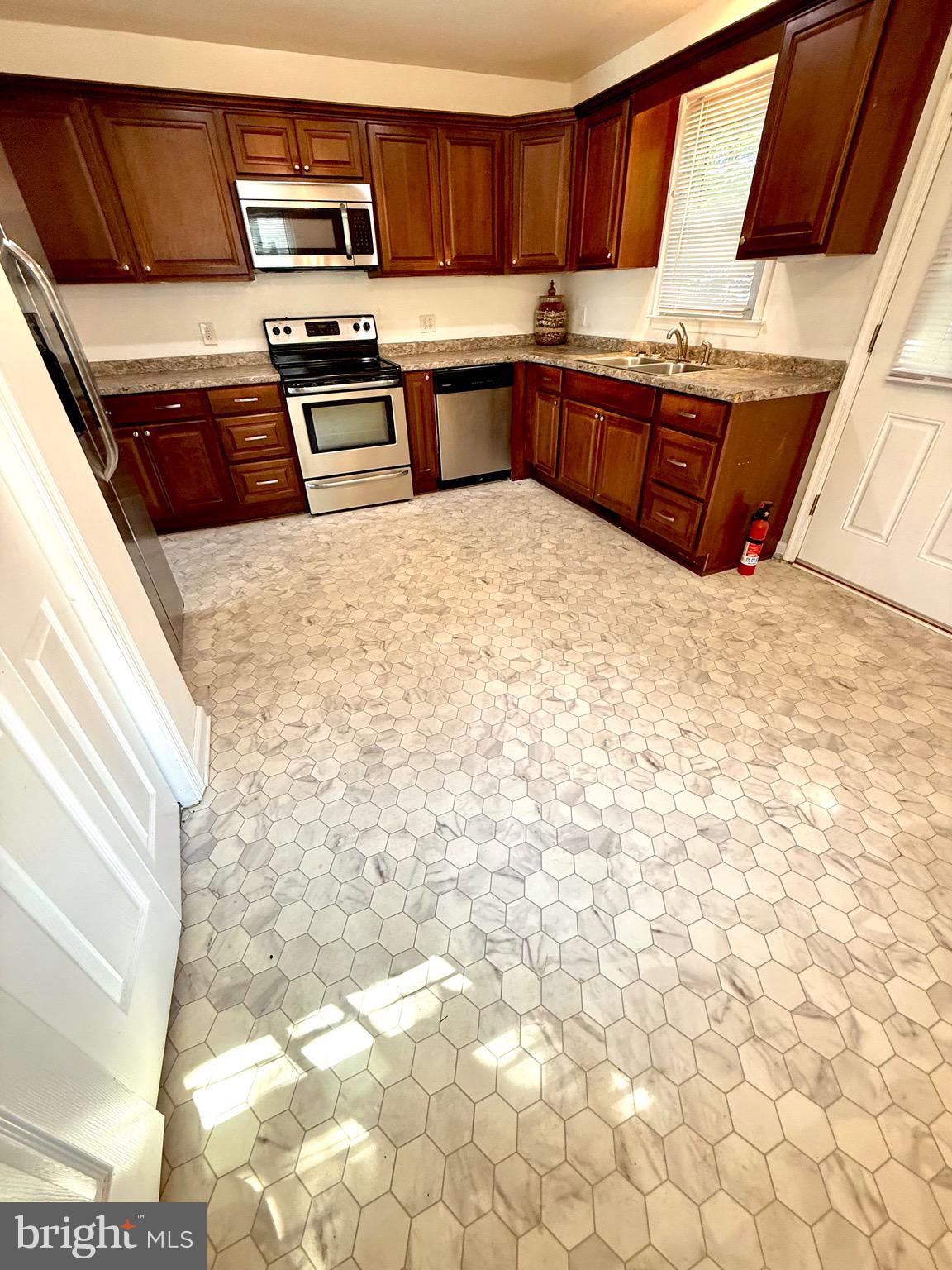 195 Mitscher Road Dover, DE 19901 - Photo 9 of 24 a kitchen with granite countertop a stove a sink and a microwave