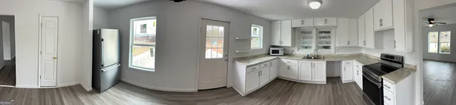 a kitchen with cabinets and wooden floor