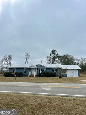 a view of a big house with a big yard and large trees