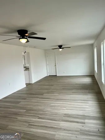 a view of empty room with wooden floor