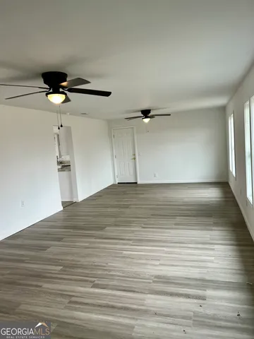 a view of empty room with wooden floor