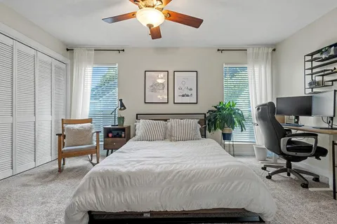 a bedroom with a bed and a computer on the desk