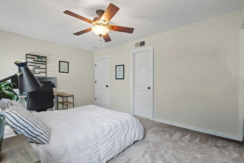 9222 Church Road, Unit 117 Dallas, TX 75231 - Photo 14 of 24 a bedroom with a large bed a chandelier and a desk