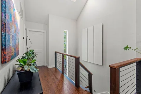 a hallway with wooden floor and a potted plant