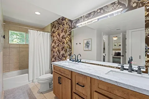 a bathroom with a double vanity sink toilet and shower