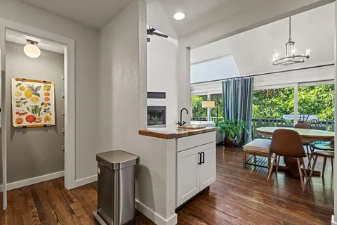 a kitchen with stainless steel appliances granite countertop a table chairs and a large window
