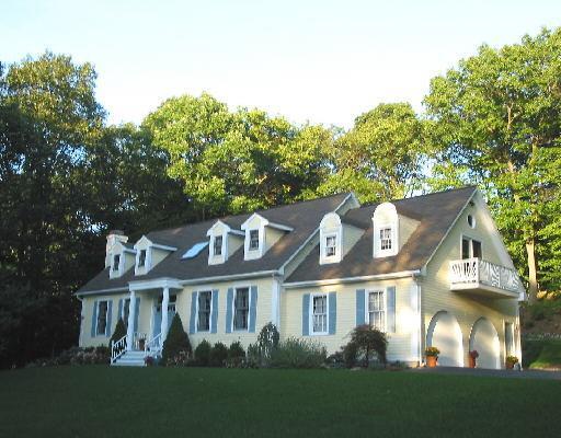 a front view of a house with a yard and trees