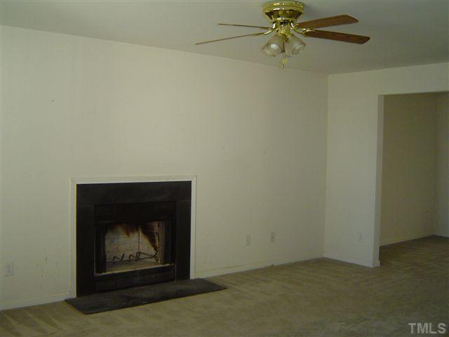 1204 Ricochet Drive Raleigh, NC 27610 - Photo 6 of 11 an empty room with a fireplace