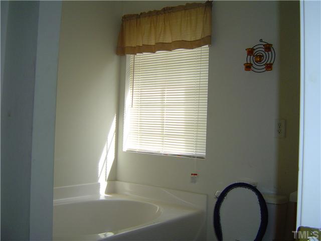 1204 Ricochet Drive Raleigh, NC 27610 - Photo 8 of 11 a bathroom with a bathtub and a window