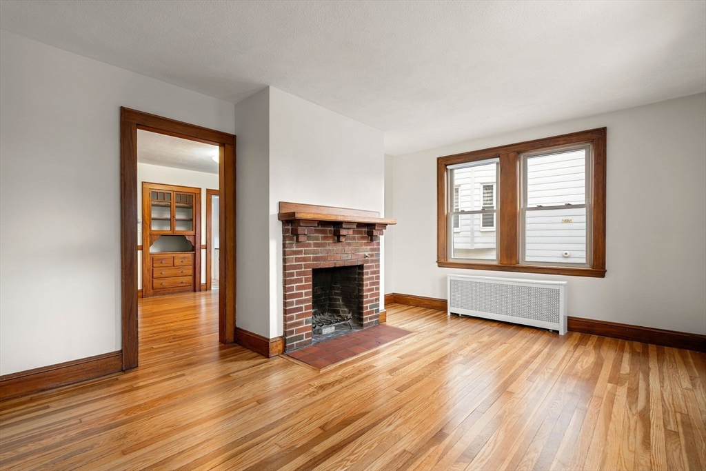 40-42 Upland Road Belmont, MA 02478 - Photo 4 of 35 wooden floor fireplace and windows in an empty room