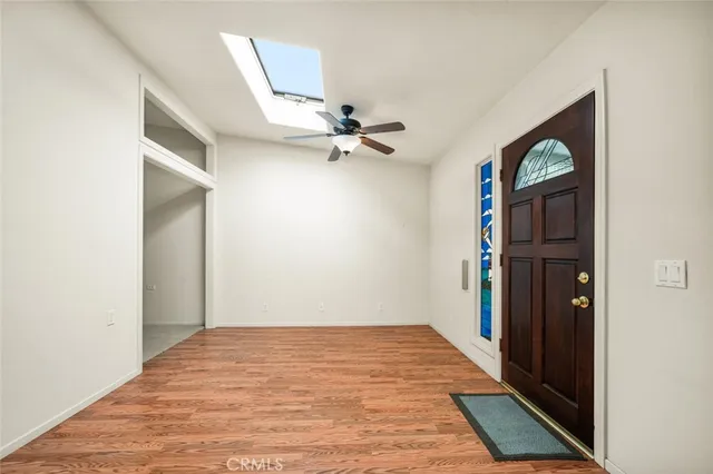 a view of a big room with wooden floor and windows