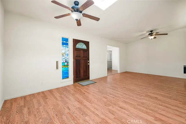 a view of a hallway with wooden floor and a ceiling fan