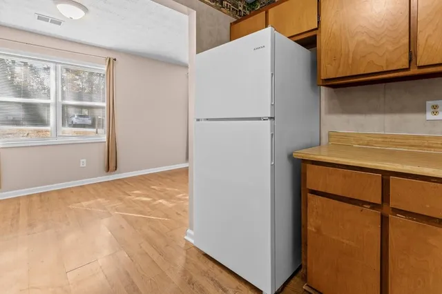 a kitchen with a refrigerator sink and cabinets
