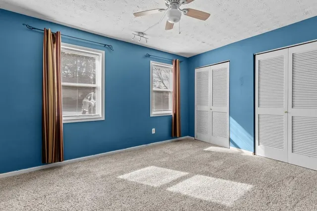 a view of a big room with closet and a ceiling fan