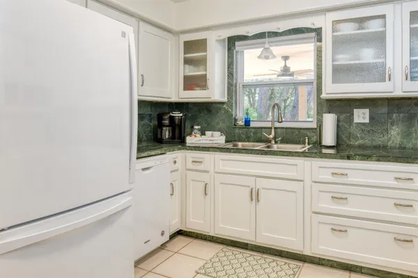 a kitchen with white cabinets and a window