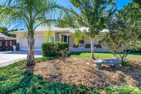 a view of a house with a backyard and tree
